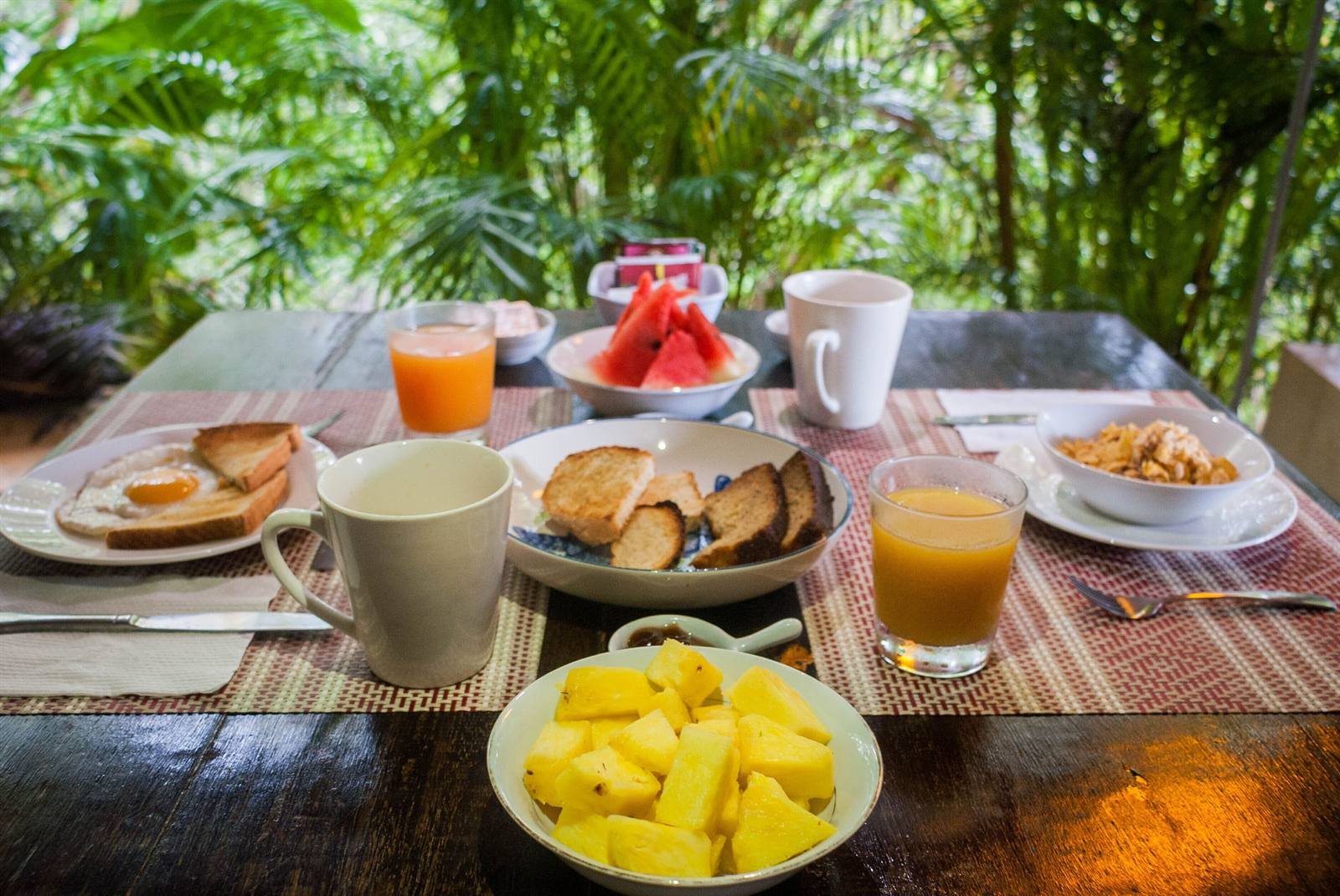 Breakfast table with a variety of fruit, bread and drinks